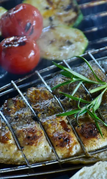 Gegrillter Fisch mit Kräutern auf dem Grill beim Grill Catering