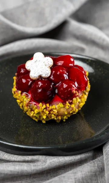 Dessert mit Kirschen und Keks als Finale beim Menü Catering